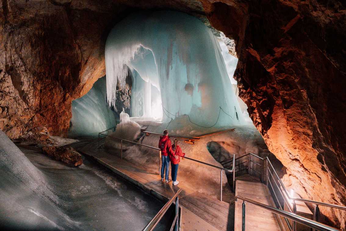Zwei Besucher vor einer gefrorenen Eiswand in der Eisriesenwelt Werfen