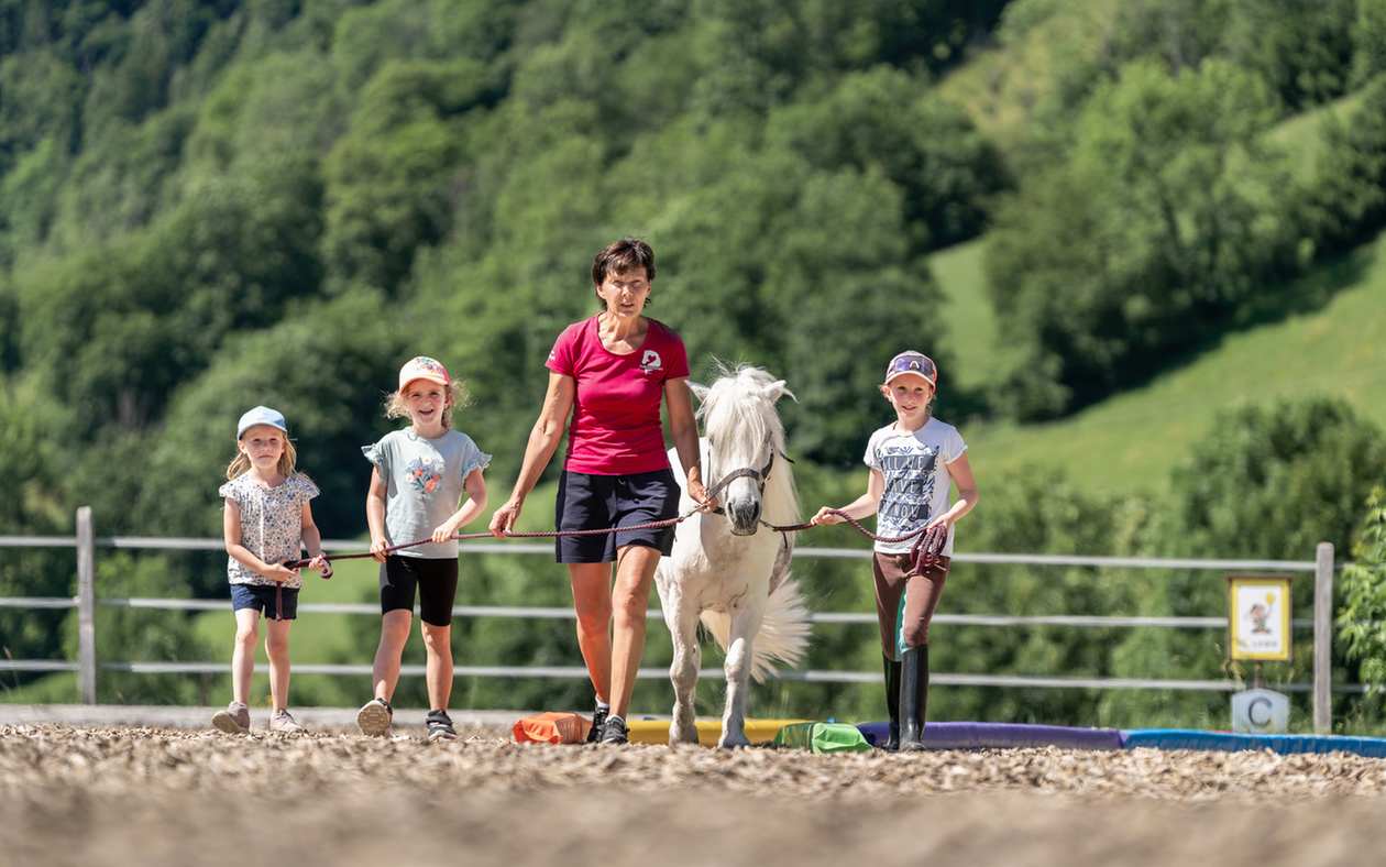 Reitpädagogin Ilona Hutter mit drei Kindern und einem weißen Pony