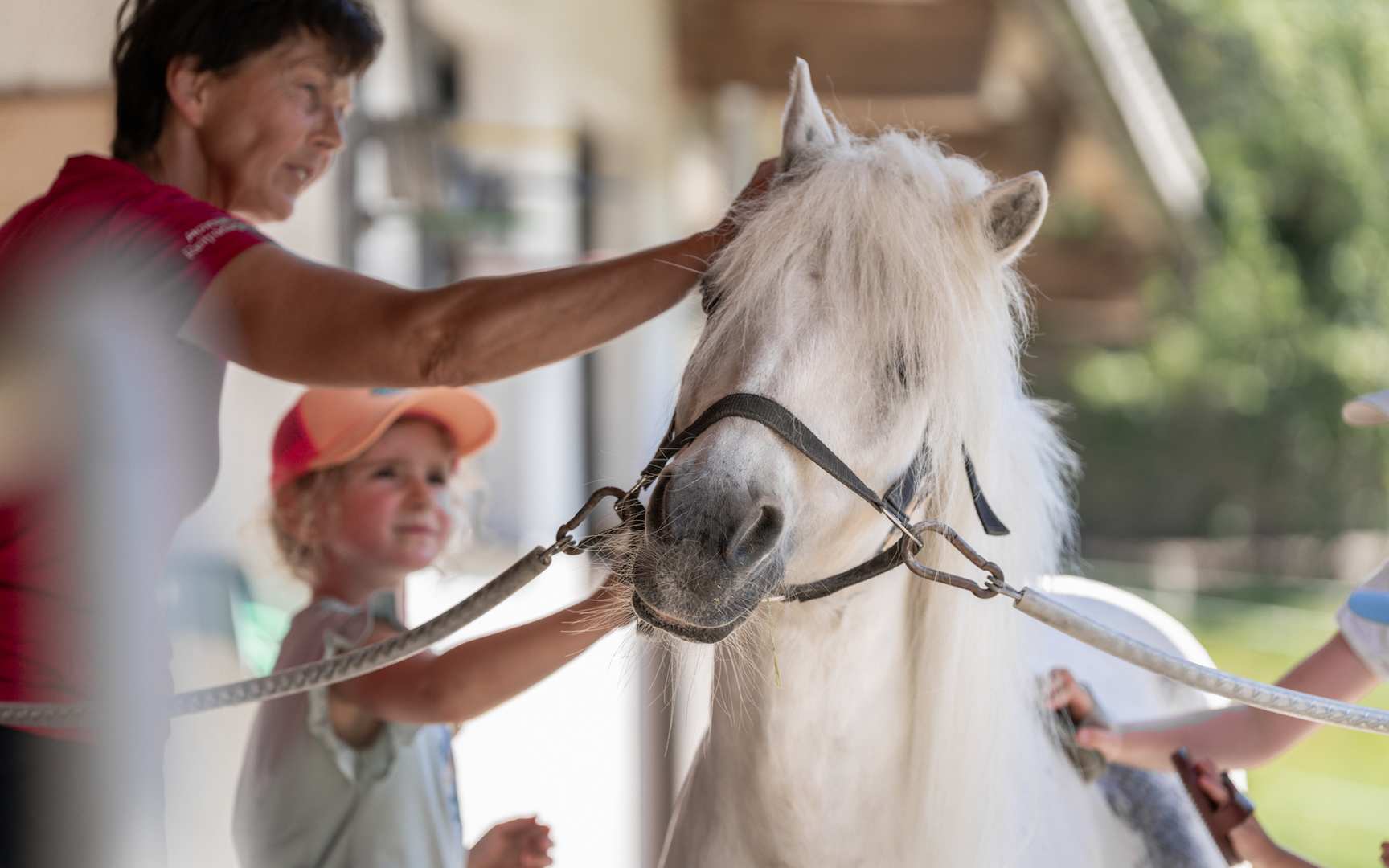 Reitpädagogin Ilona Hutter mit Kindern und weißem Pony am Tobhartbauer in Dorfgastein