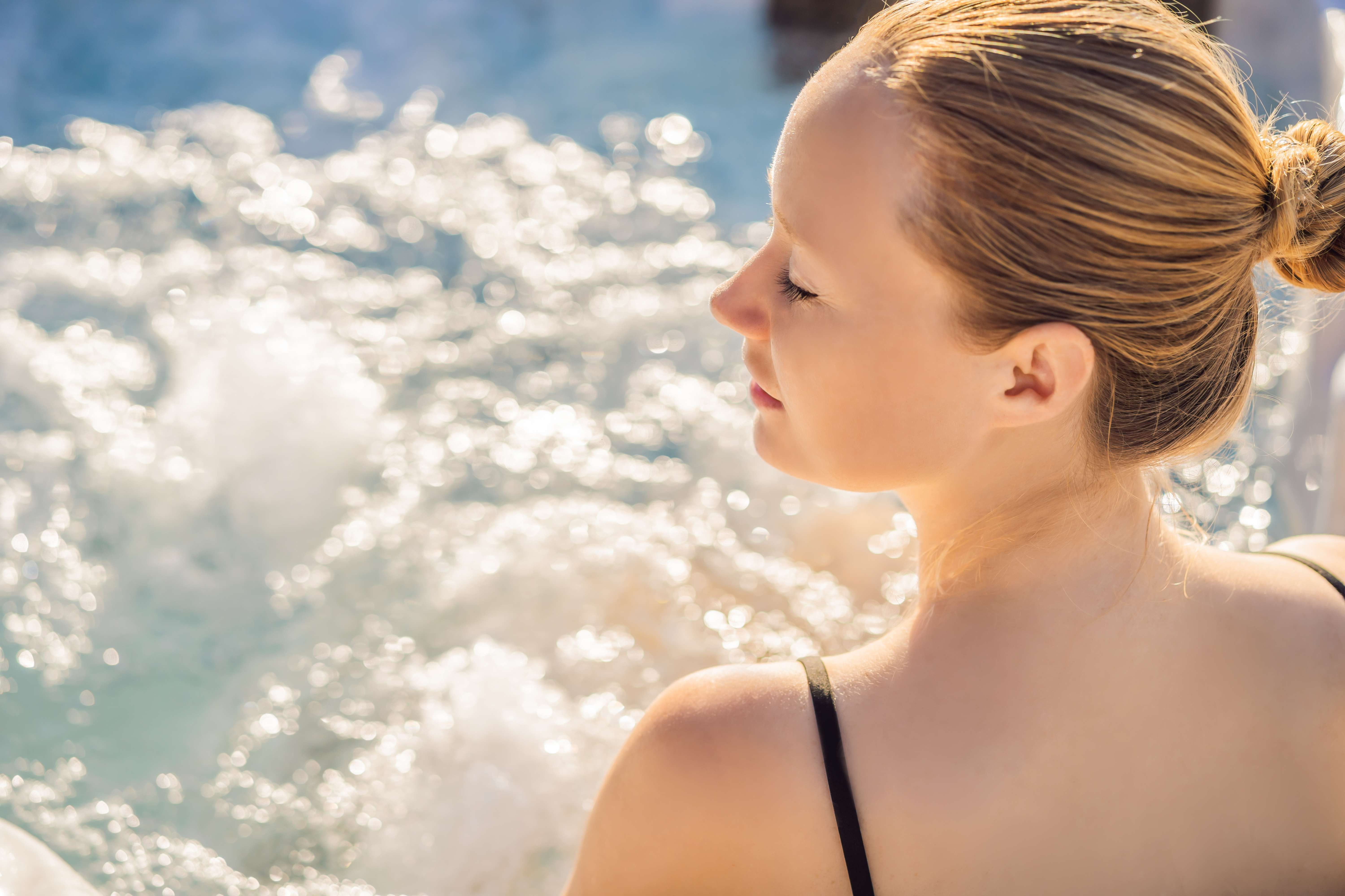 Frau entspannt im warmen Thermalwasser