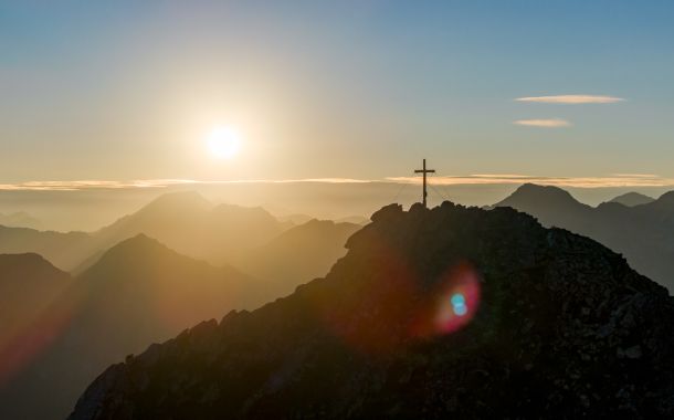 Sonnenaufgang am Gipfelkreuz in den Gasteiner Bergen
