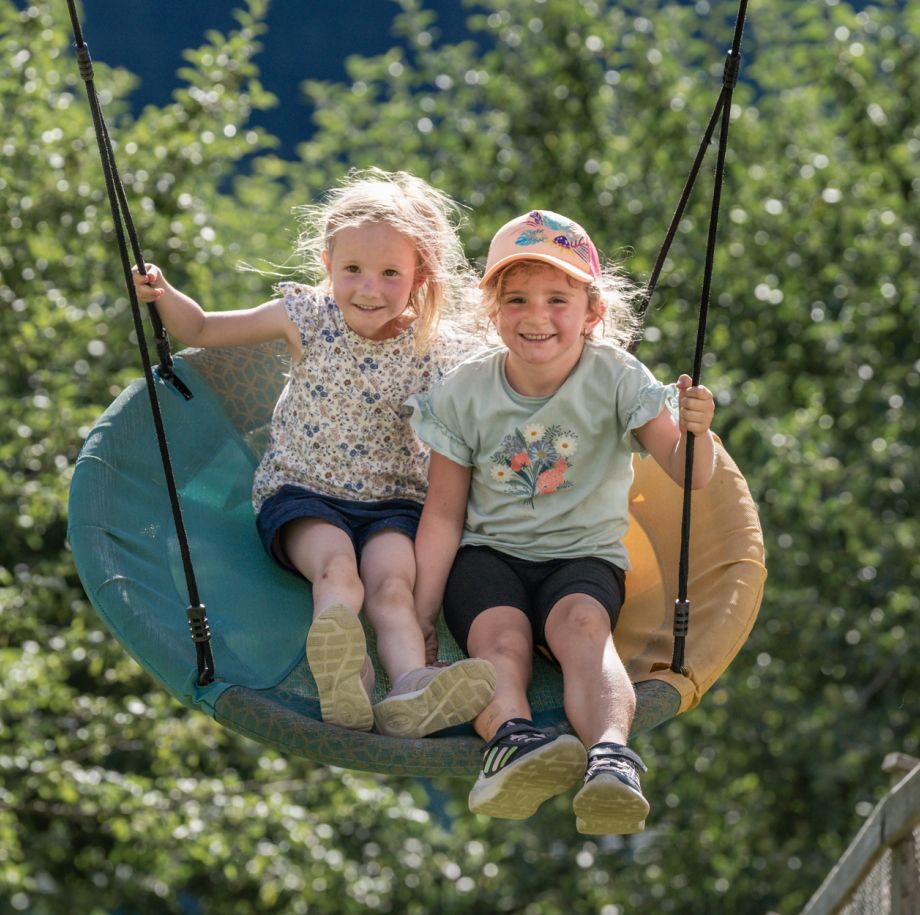 Zwei Kinder auf der Nestschaukel am Tobhartbauer