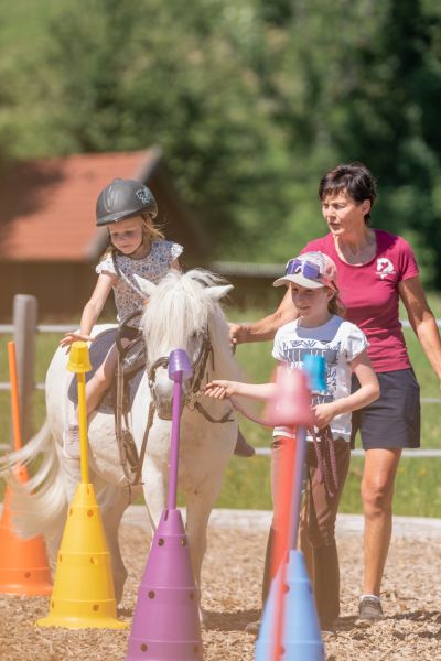 Reitpädagogin Ilona Hutter begleitet zwei Kinder mit einem Pony am Tobhartbauer in Dorfgastein