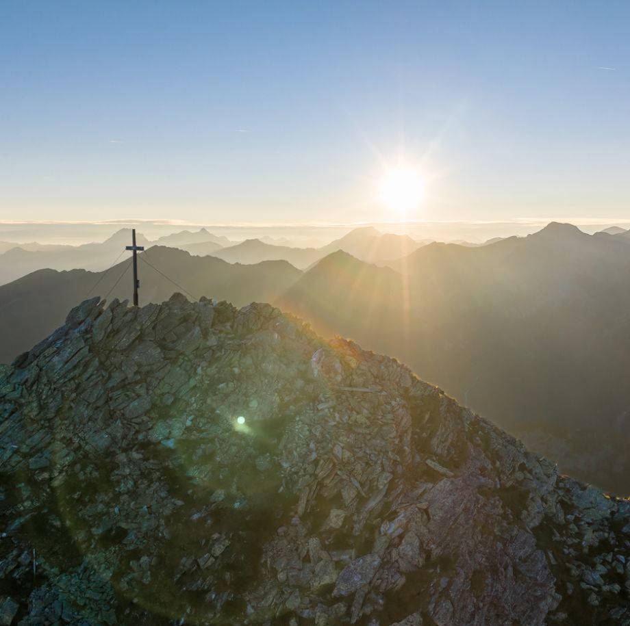 Sonnenaufgang am Gipfelkreuz in den Gasteiner Bergen