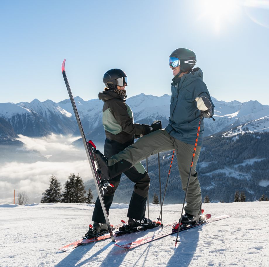 Zwei Skifahrer im Skigebiet Gastein vor alpiner Bergkulisse