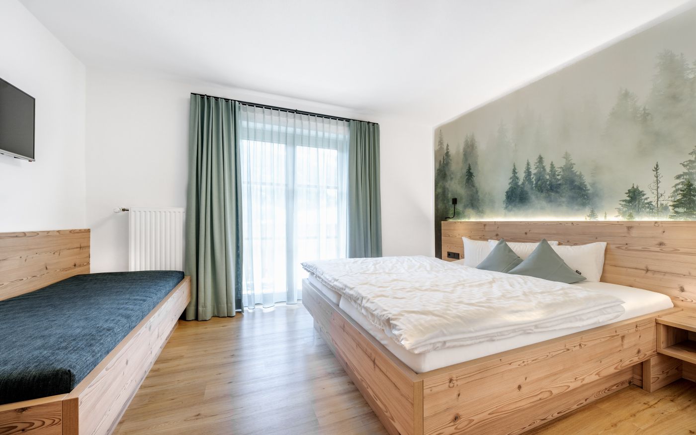 Schlafzimmer mit Doppelbett und Einzelbett in der Ferienwohnung Kieserl