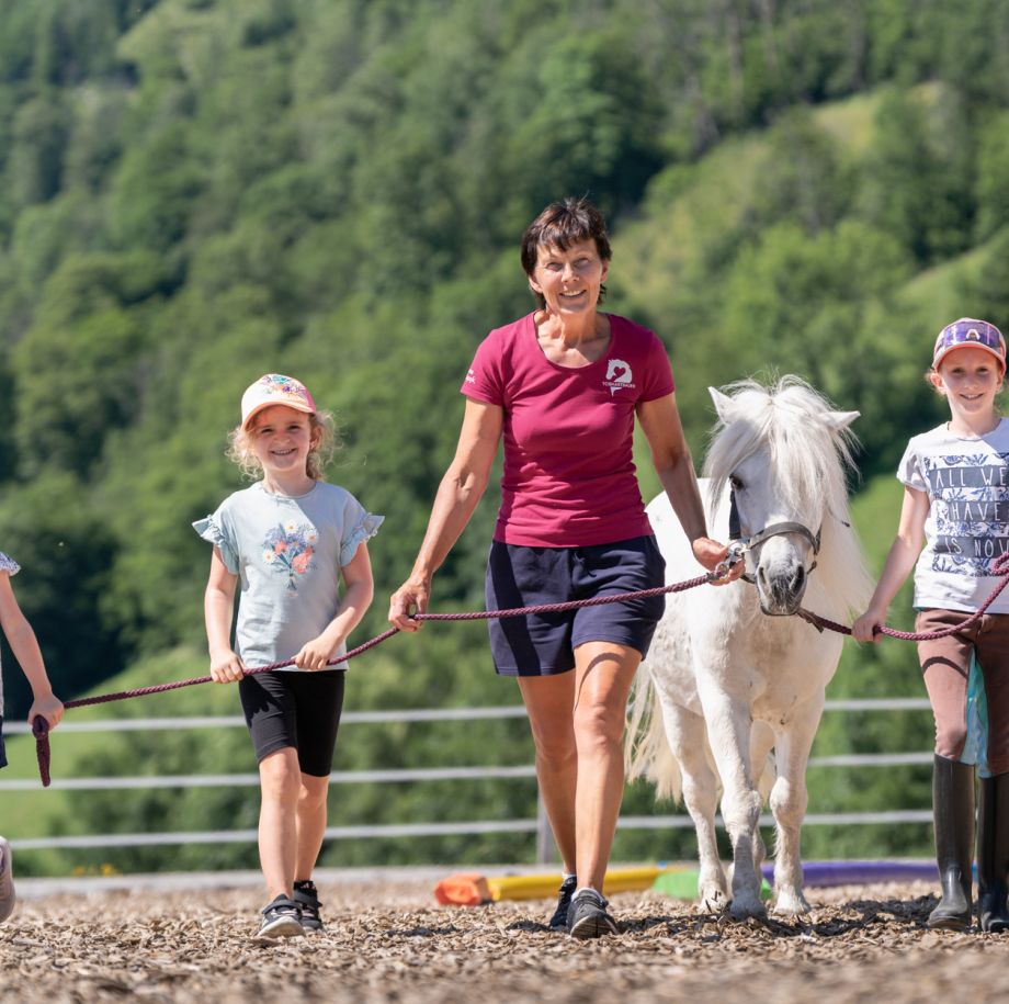 Reitpädagogin mit zwei Kindern und weißem Pony am Tobhartbauer