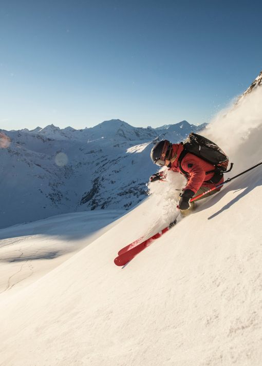 Skifahrer im Tiefschnee vor der Bergkulisse des Gasteinertals