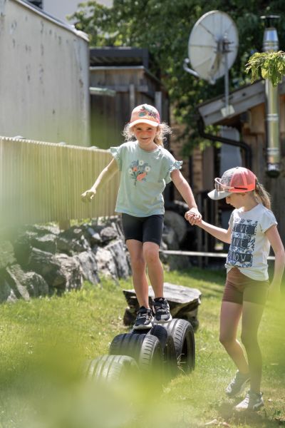 Zwei Kinder spielen im Garten des Tobhartbauers