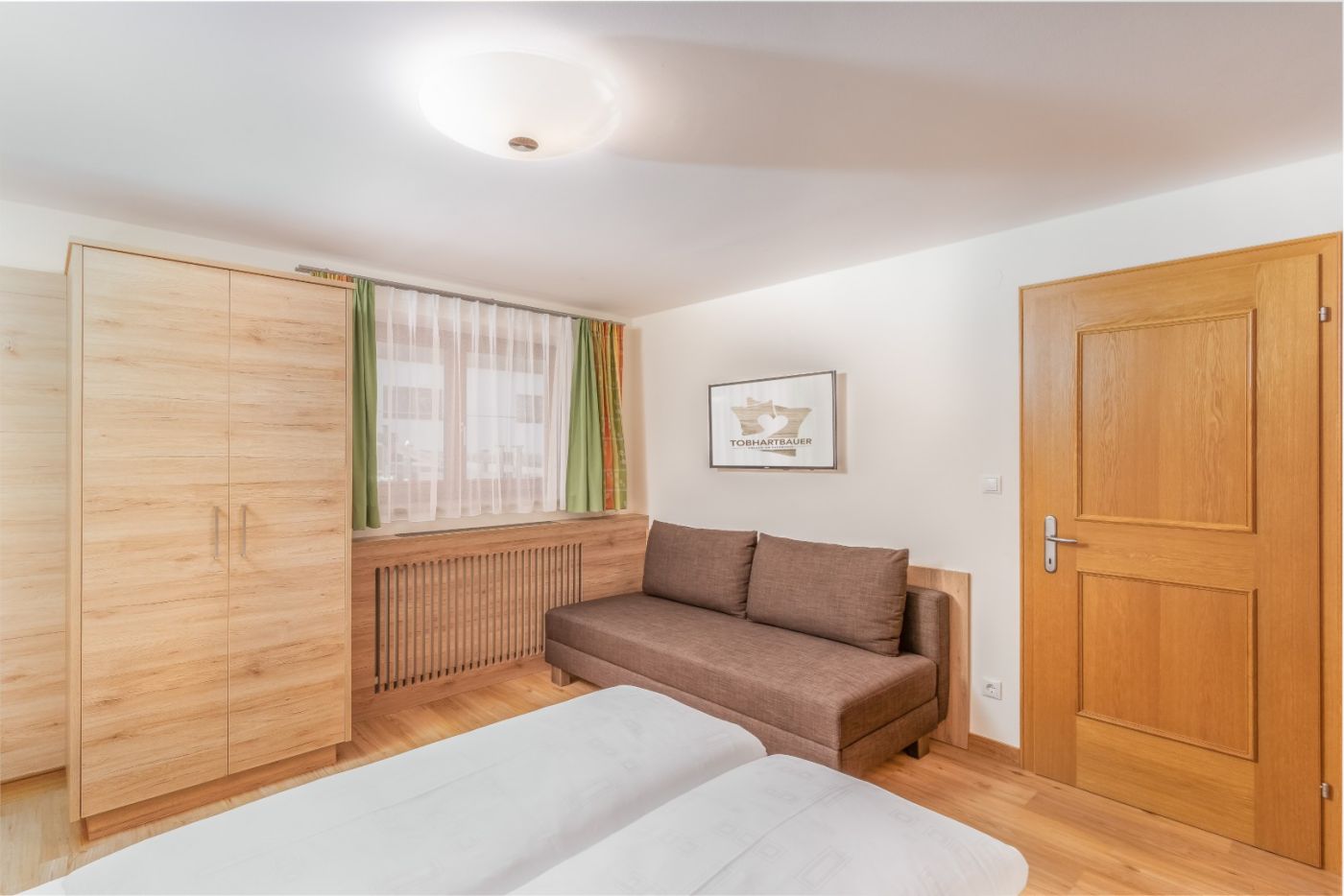Schlafzimmer mit Zusatzbett in der Ferienwohnung Bernkogel