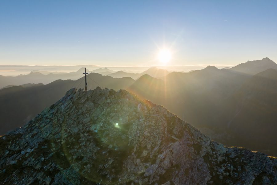 Sonnenaufgang am Gipfelkreuz in den Gasteiner Bergen